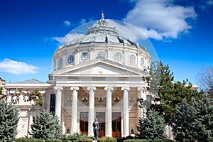 Ateneul Roman main facade in front of a park during a sunny afternoon. with the mention Ateneul Roman meaning in Romanian