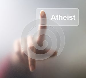 Atheist button. Woman finger pressing a glass atheist button on grey background photo