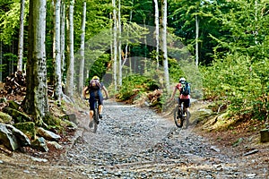 Atheletes ride on bike in mountain forest.