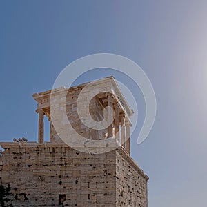 Athena Nike temple with Ionian style columns, standing by the entrance of Acropolis, with space for text.