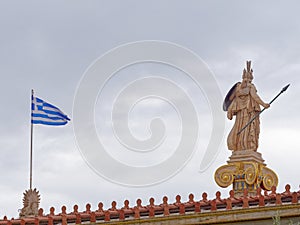 Athena statue and Greek flag under heavy clouds sky background