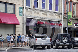 A group of young adults wait in line to enter a restaurant in downtown Athens, Georgia