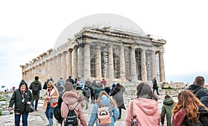 Athens, Greece - February 23, 2019: Tourists visit Parthenon temple at the Acropolis in Athens. View on the side of the western