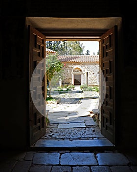 Athens Greece, Kaisariani monastery main yard view through chapel`s door photo