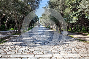 Athens, Greece. People walk on a cobblestone pathway at Filopappou hill