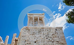 Athens, Greece. Propylaea and Temple of Athena Nike in the Acropolis, monumental gate, blue cloudy sky in spring sunny day