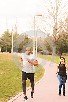 Athetic couple running on footpath in the park photo