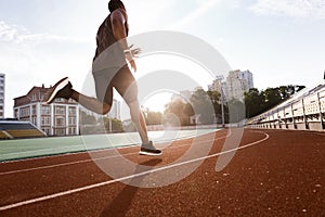 Athlete african man running on racetrack