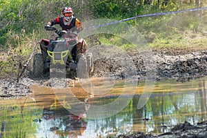 Athlete on the ATV is reflected in the water