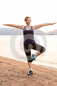 Athlete balances on one foot on the beach