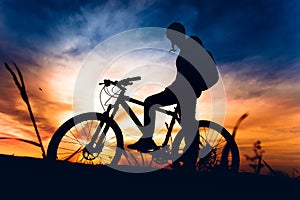 Athlete biker riding mountain bike at sunset