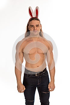 Athlete bodybuilder shirtless with long hair posing with a rabbit-like ears