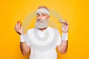 Athlete cool grandpa holds forbidden junkfood cheeseburger and f photo