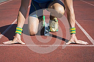 Athlete Crouching at Running Track Starting Blocks