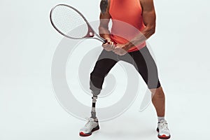 Athlete with disabilities or amputee isolated on white studio background. Professional male tennis player with leg