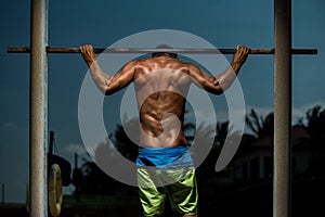 Athlete doing pull-up on horizontal bar