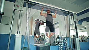 Athlete doing pull-up on horizontal bar in the gym