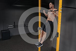 Athlete doing pull ups at gym