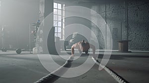 Athlete doing push ups in gym. Man making fitness training in loft building