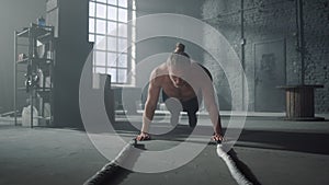 Athlete doing push ups in gym. Man making fitness training in loft building