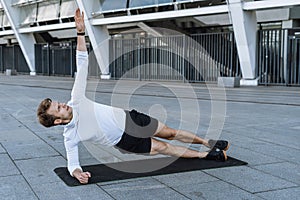 Athlete doing side plank on yoga mat