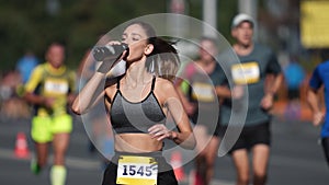 Athlete drink water bottle. Thirsty person run. Woman runner jog sport marathon.