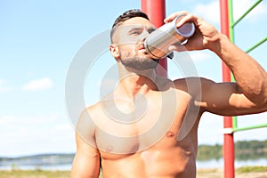 Athlete drinking water and relaxing after intense workout outdoors