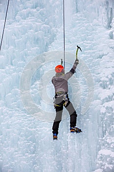 The athlete is engaged in winter mountaineering. Ice Wall Climbing