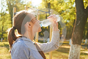 An athlete girl drinks clean water after training. Dry mouth, restoration of vital energy.