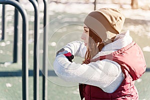 Athlete girl in warm clothes on sunny day does an exercise lunges with lunges the sports field outdoor in winter in