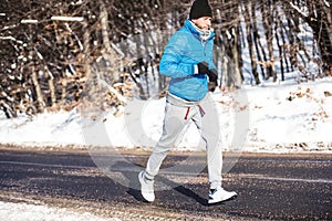 Athlete going for a run outdoor in snow, hardcore training and jogging