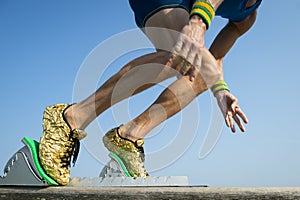 Athlete with Gold Running Shoes Starting a Race