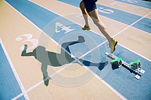 Athlete in Gold Shoes Sprinting Across Starting Line