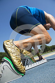 Athlete in Gold Shoes on Starting Blocks