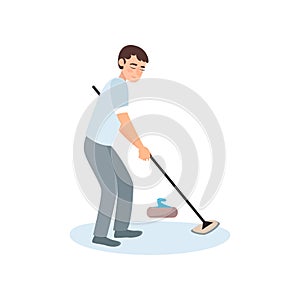 An athlete in gray clothes on the ice is rubbing the floor with a brush, thus pushing a stone.