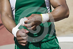 Athlete In Green Sportswear Taping Wrist photo