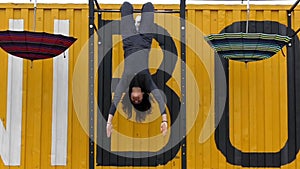 The Athlete Hanging on the Bar Upside Down. the Action in Slow Motion. Girl