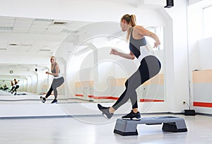 Athlete having a step aerobics in a gym photo