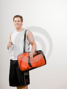 Athlete holding gym bag and water bottle