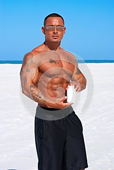 Athlete holding product container at the beach