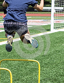 Athlete jumping over mini hurdles