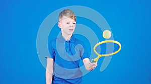Athlete kid tennis racket on blue background. Tennis sport and entertainment. Boy child play tennis. Practicing tennis