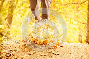 Athlete makes a morning run through the autumn forest. Foliage on a park treadmill and athlete`s feet.