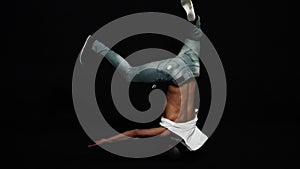 Athlete male break dancer with put on bike helmet actively spins on his head