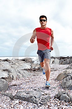 Athlete male person, running and beach for fitness, health and wellness in activewear and sunglasses. Man, jog and