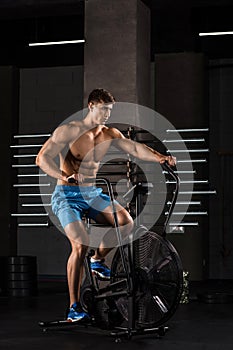 Athlete man biking in the gym.