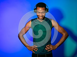 Athlete Man In Fitwear And Earphones Standing On Blue Background