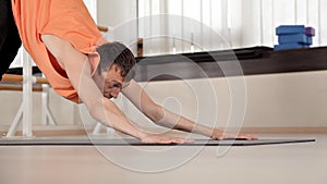 Athlete-man makes torso turns, sitting on the floor in the gym, yoga exercises.Health, life, flexibility