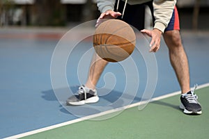 Athlete man playing basketball in an urban court. Sport and active lifestyle concept