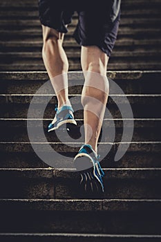 Athlete man with strong leg muscles training and running urban city staircase in sport fitness and healthy lifestyle concept